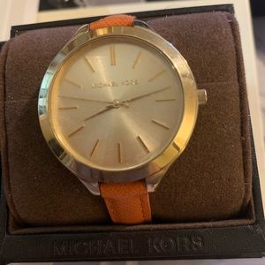 Michael Kors used gold and orange bracelet.